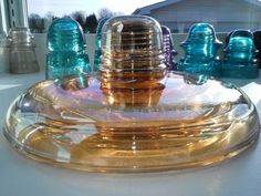 a clear glass bottle sitting on top of a table next to other blue and gold bottles