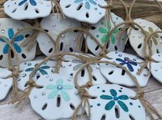 some white sand dollar ornaments with blue and green designs