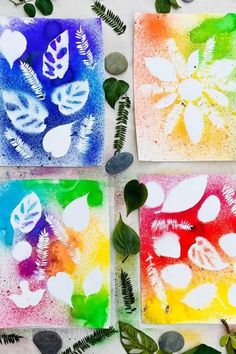 four square paintings with leaves and hearts on them, all painted in different colors from green to blue