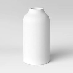 a white vase sitting on top of a table