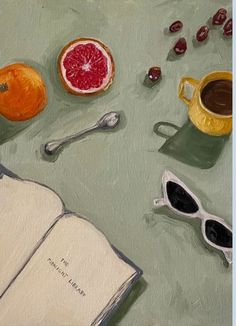 an open book sitting on top of a table next to fruit and coffee cup with spoons