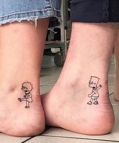 two people with matching tattoos on their feet, one has a small cartoon character and the other has a cat