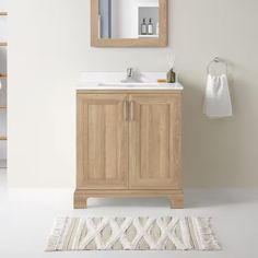 a bathroom with a sink, mirror and rug on the floor in front of it