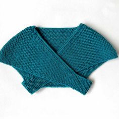 two blue knitted mittens sitting on top of each other