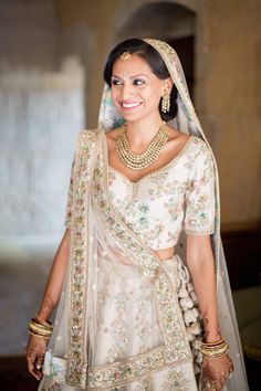 a woman wearing a bridal outfit and jewelry