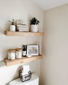 two wooden shelves above a toilet in a bathroom