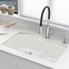 a white kitchen sink sitting under a window