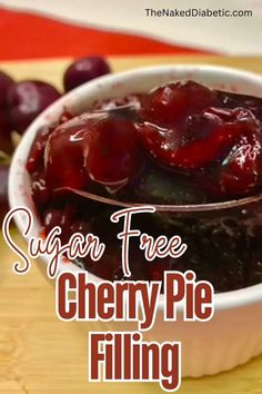 a bowl filled with cherries sitting on top of a wooden table