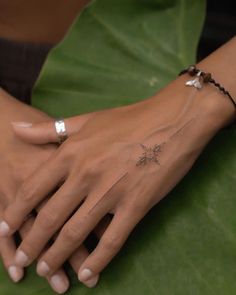 a woman's hand with a small star tattoo on her left arm and wrist