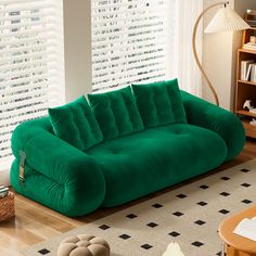 a green couch sitting in the middle of a living room