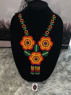 a black necklace with flowers and beads on display in front of the eiffel tower