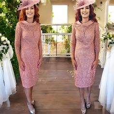 two women in pink dresses and hats standing next to each other on a wooden floor