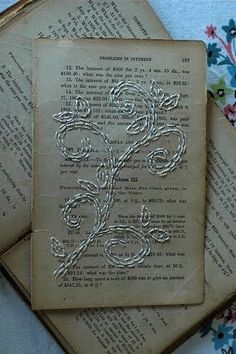 three old book pages with intricate designs on them sitting next to each other in front of a flowery background