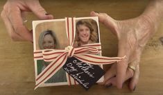 a person holding up a card with two pictures on it and a ribbon tied around it