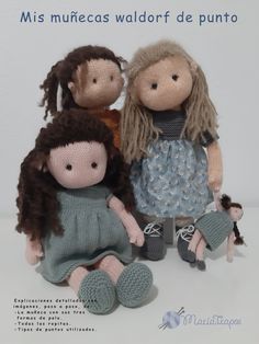 three knitted dolls sitting next to each other on a white surface with one holding a doll's leg