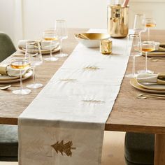 the table is set with glasses, plates and napkins for dinner guests to enjoy