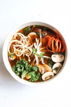 a white bowl filled with noodles and vegetables