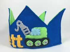 a blue felt crown with a green and yellow truck on it's front side