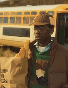 a man holding a paper bag next to a train