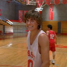 a young man standing on top of a basketball court