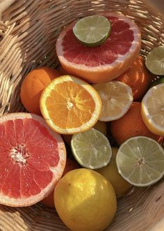 a basket filled with citrus fruit sitting on top of a table