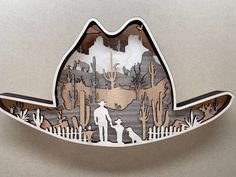 a paper cut cowboy hat with an image of a man and his dog