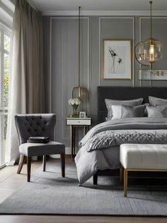 a bedroom with gray walls and white bedding, two chairs and a large window