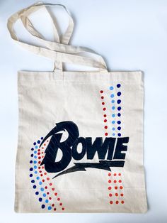 Tote bag with Bowie logo , hand painted  Size :  Height 16.5 inches  Width 15 inches Handle 13 inches Care instructions: machine washing, lowest temperature, iron with cotton cloth placed on design Handpainted Tote, Handpainted Tote Bags, Logo Hand, David Bowie, Tote Bags, Care Instructions, Chiffon, Hand Painted, Tote Bag