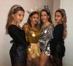 three women in gold and silver outfits posing for the camera with one woman wearing a crown