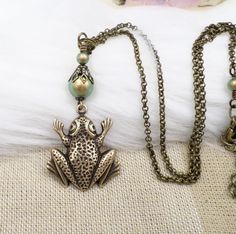 This charming necklace features a brass pendant in the shape of a frog/toad, with a green imitation pearl as the main stone. The necklace is 16 1/2 inches long and has an adjustable cable chain with a lobster closure. The necklace is handmade and has a unique beaded style with a vintage appeal. Perfect as a gift for Mother's Day, an anniversary, or a birthday, this necklace embodies the beauty of nature and animals, making it a great addition to any bohemian or cottagecore outfit. The necklace is signed by Jewelry518 and comes from the United States. Whether for personal use or as a gift, this necklace is a beautiful choice that will add a touch of art and beauty to any outfit. Cottagecore Outfit, Cottagecore Gifts, Frog Jewelry, Frog Necklace, Nature And Animals, Gift Girlfriend, A Frog, Brass Pendant, Fashion Jewelry Necklaces