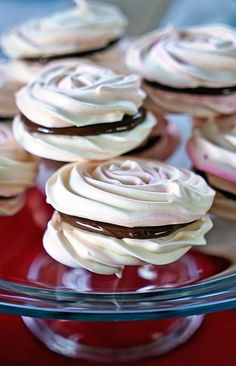 some cupcakes with white frosting and chocolate on top are in a glass dish