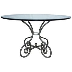 a glass table with wrought iron legs