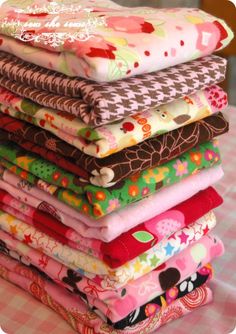 a stack of cloths sitting on top of a pink and white checkered tablecloth