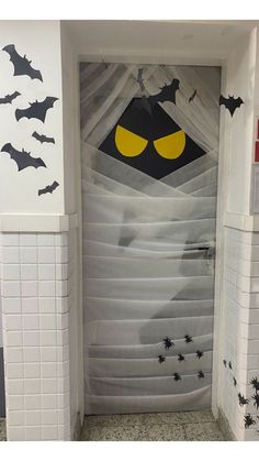 an open door decorated with bats and spider webs in the shape of a bat