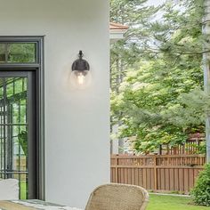 a table and chairs on a porch with an open door to the back yard area