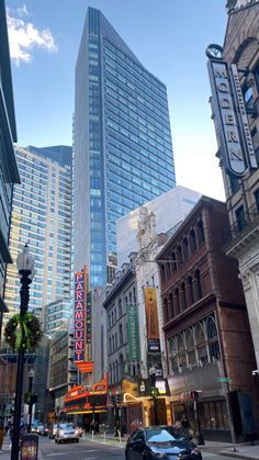 a city street with tall buildings and cars parked on the side of the road in front of it