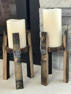 two wooden candles sitting next to each other in front of a fire place with a fireplace