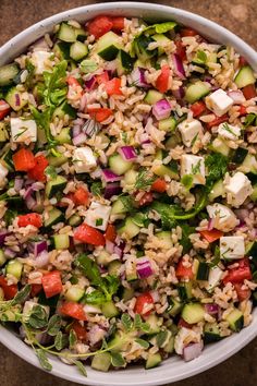 a white bowl filled with rice salad on top of a table