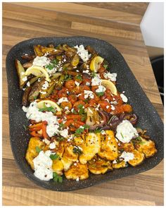 a large platter filled with lots of food on top of a wooden table