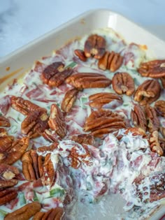 a close up of a cake with pecans on it