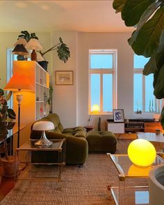 a living room filled with lots of furniture and plants on top of it's walls