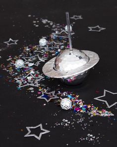 silver confetti dish on black table with stars and streamers in the background