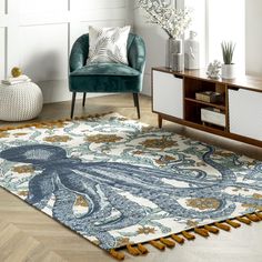 a living room area with a blue chair and white rug on the floor next to a wooden table