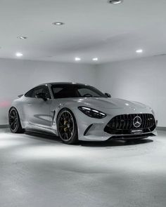 the mercedes amg gt is parked in a large room with white walls and flooring