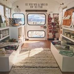 the inside of a small store with lots of items on shelves and rugs in front of it