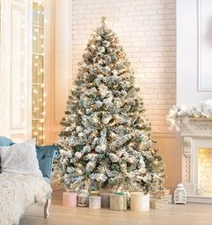 a decorated christmas tree in front of a fireplace with presents on the floor next to it