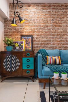 a living room filled with furniture and a brick wall behind the couch is a coffee table