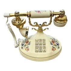 an old fashioned phone is decorated with flowers and gold trimmings on it's sides