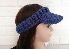 a woman wearing a blue crocheted headband on top of a mannequin's head