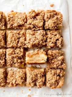 apple crumb bars cut into squares on top of parchment paper